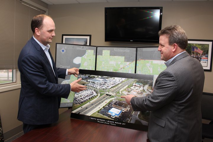 Fishers Mayor Scott Fadness, left, and Hamilton County Commissioner Mark Heirbrandt look over a proposed rendering of a roundabout at the intersection of State Road 37 and 126th Street. (Photo by James Feichtner)