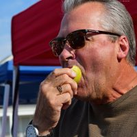 David Payne of Greenwood takes bites into an apple pear at the Pop Up Farmers' Market in Boone Village. (Photo by Dawn Pearson)
