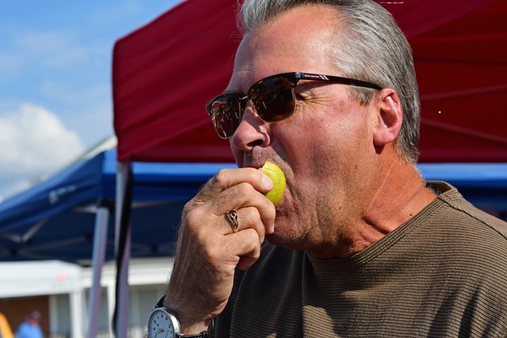 David Payne of Greenwood takes bites into an apple pear at the Pop Up Farmers' Market in Boone Village. (Photo by Dawn Pearson)